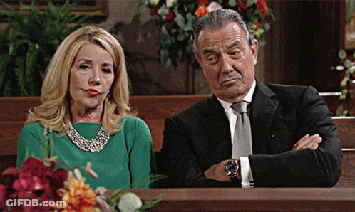 A Woman In A Green Dress Sits Next To A Man In A Suit GIF