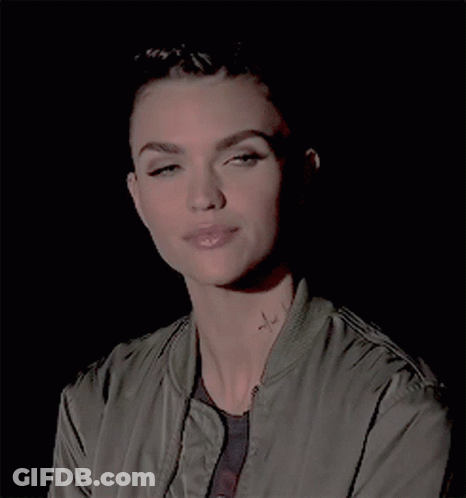 A Woman In A Green Jacket Has A Tattoo On Her Neck GIF