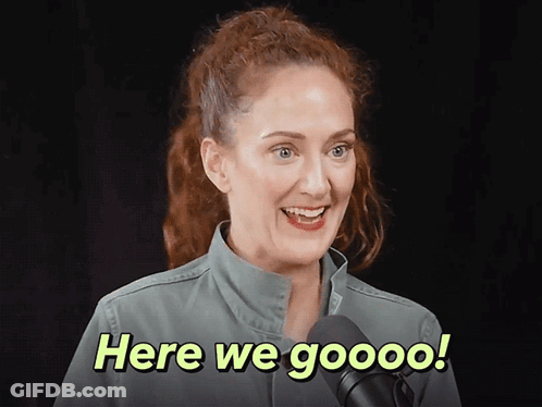 A Woman In A Green Jacket Is Smiling And Says Here We Goooo GIF