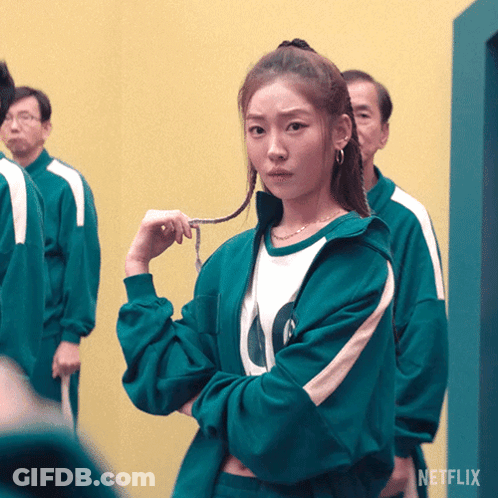 A Woman In A Green Jacket With The Letter O On The Front GIF