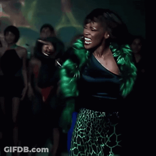 Woman In Green Leopard Print Skirt Dancing In Dark Room GIF
