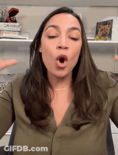 A Woman In A Green Shirt Is Making A Face With Her Mouth Open GIF