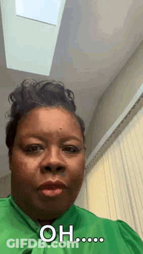 A Woman In A Green Shirt Is Making A Funny Face And Saying Oh ... GIF