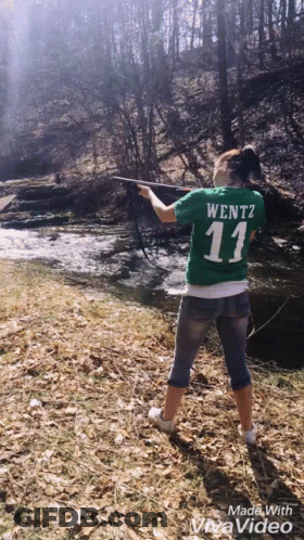 A Woman In A Green Shirt With The Number 11 On It Is Fishing GIF