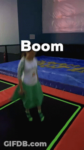 A Woman In A Green Skirt Is Jumping On A Trampoline And The Word Boom Is Above Her GIF