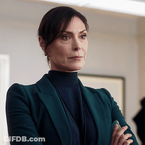 A Woman In A Green Suit And Black Turtleneck GIF