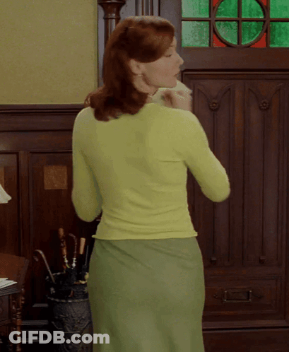 A Woman In A Green Sweater And Green Skirt GIF
