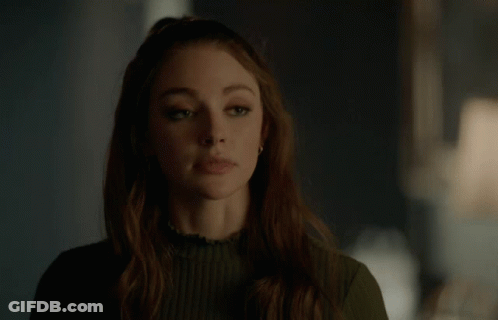 A Woman In A Green Sweater Is Making A Funny Face GIF