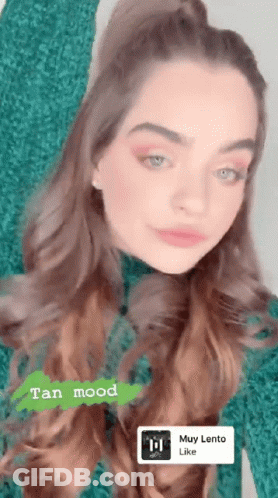 A Woman In A Green Sweater With A Tan Mood Sticker On Her Face GIF