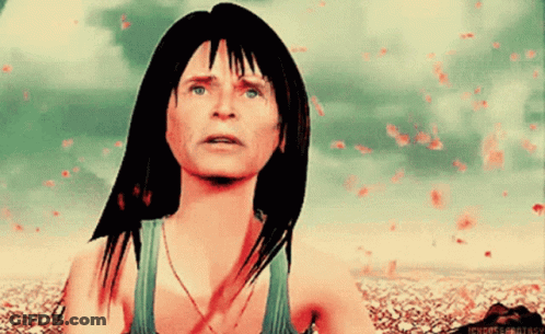 A Woman In A Green Tank Top Is Looking Up At Something GIF