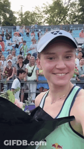A Woman In A Green Tank Top With A Red Bull On It GIF