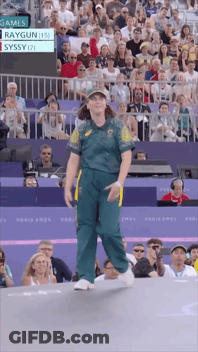 A Woman In A Green Uniform Stands In Front Of A Crowd At A Sports Event GIF