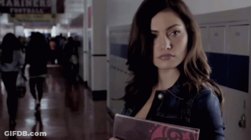 A Woman In A Hallway With A Sign That Says Mariners GIF