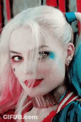 A Woman In A Harley Quinn Costume Is Smiling GIF