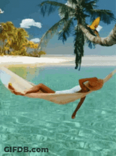 A Woman In A Hat Is Laying In A Hammock In The Ocean GIF