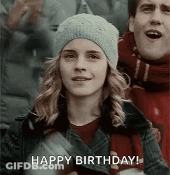 A Woman In A Hat Is Standing Next To A Man In A Scarf And A Man Is Singing Happy Birthday . GIF