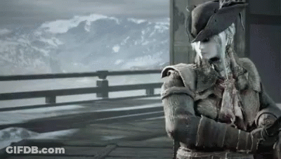 A Woman In A Hat Stands On A Balcony Overlooking A Snowy Mountain Range GIF