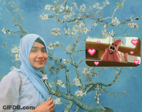 A Woman In A Hijab Is Standing In Front Of A Tree With Flowers GIF