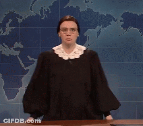 A Woman In A Judge 'S Robe And Glasses Is Standing In Front Of A Map Of The World . GIF