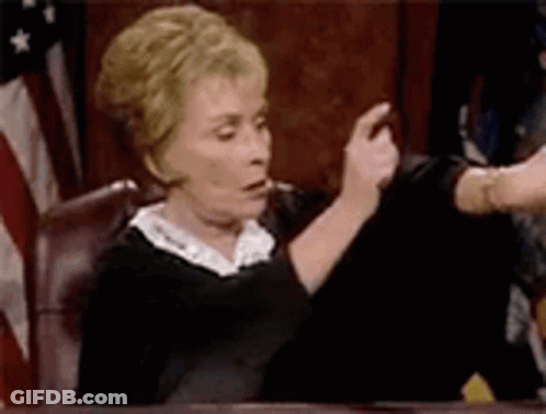 Woman Judge Sitting In Court In Front Of Flag GIF