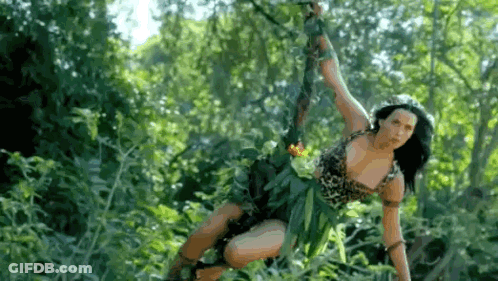 A Woman In A Jungle Outfit Is Hanging From A Rope In The Trees . GIF