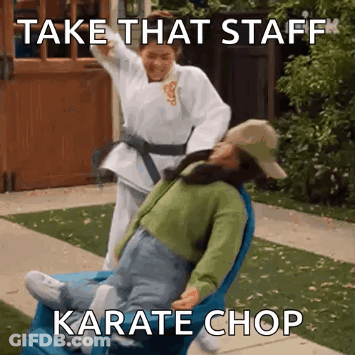A Woman In A Karate Uniform Is Pushing A Woman In A Wheelchair . GIF