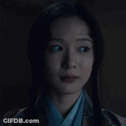 A Woman In A Kimono Is Looking At The Camera GIF