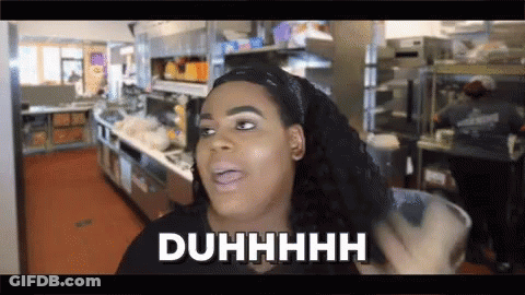 A Woman In A Kitchen With The Word Duhhhh Written On Her Face GIF