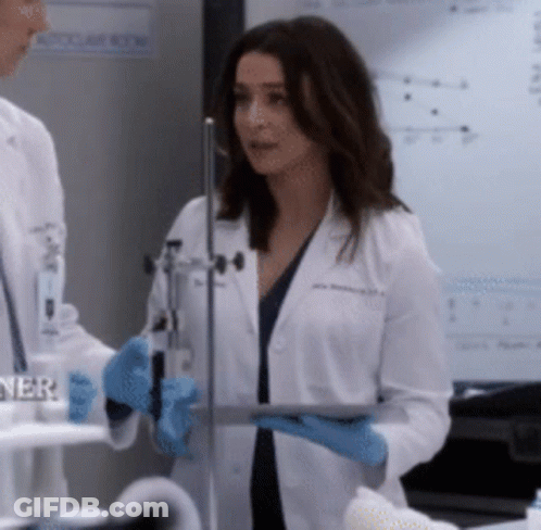 A Woman In A Lab Coat Holding A Tablet GIF