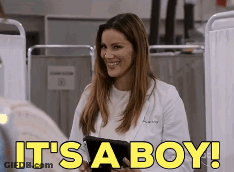 A Woman In A Lab Coat Is Smiling And Holding A Tablet With The Words It 'S A Boy Written On It GIF