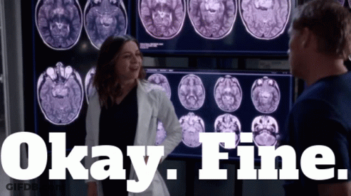 A Woman In A Lab Coat Is Standing In Front Of A Screen That Says Okay Fine GIF