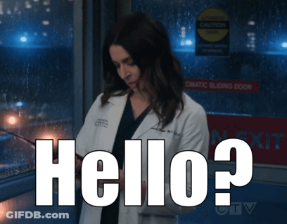 A Woman In A Lab Coat Is Standing In Front Of A Sign That Says " Automatic Sliding Door " GIF