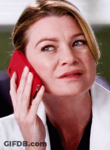 A Woman In A Lab Coat Is Talking On A Red Phone GIF