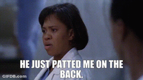 A Woman In A Lab Coat Is Talking To A Man In A Hospital Room And Says He Just Patted Me On The Back . GIF