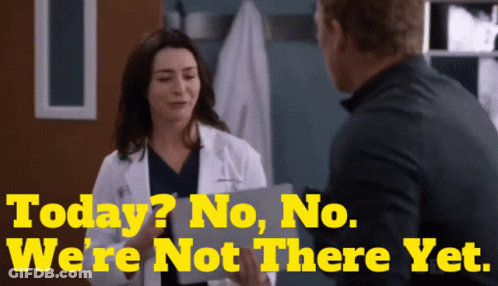 A Woman In A Lab Coat Is Talking To A Man With The Words Today No No We 'Re Not There Yet Behind Her GIF