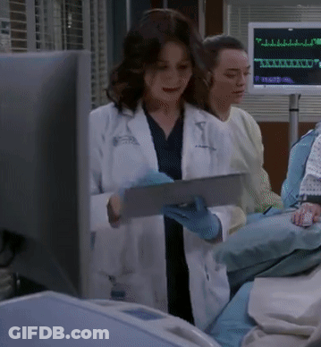 A Woman In A Lab Coat Is Using A Tablet GIF