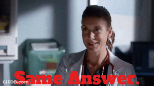 Woman In Lab Coat Smiling In Front Of Same Answer Sign GIF