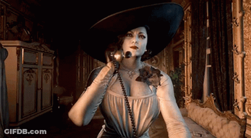 A Woman In A Large Hat Is Talking On A Phone In A Room . GIF