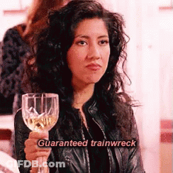 A Woman In A Leather Jacket Is Holding A Wine Glass With The Words `` Guaranteed Trainwreck '' Written On It . GIF