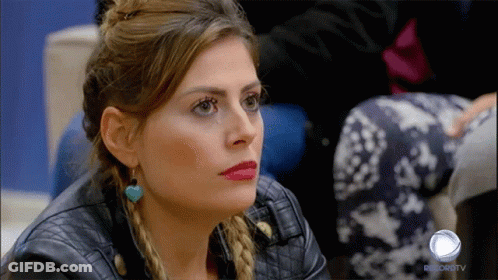 A Woman In A Leather Jacket Is Sitting In Front Of A Record Tv Logo GIF