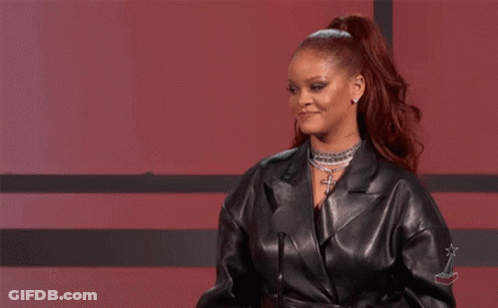 A Woman In A Leather Jacket Is Standing In Front Of A Microphone And Giving A Speech . GIF