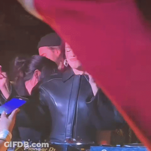 A Woman In A Leather Jacket Is Standing In Front Of A Pioneer Dj Machine . GIF