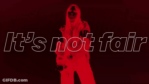 A Woman In A Leather Jacket Is Standing In Front Of A Sign That Says It 'S Not Fair GIF