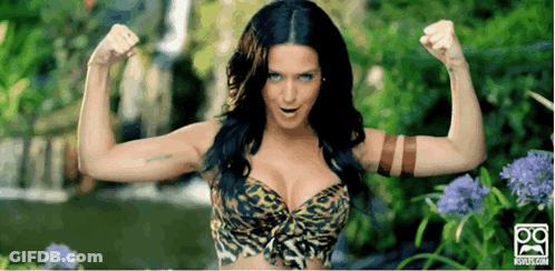 A Woman In A Leopard Print Bra Is Flexing Her Muscles GIF