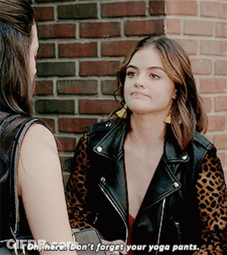 A Woman In A Leopard Print Jacket Is Talking To Another Woman In Front Of A Brick Wall GIF