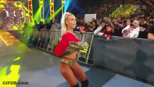 A Woman In A Leopard Print Outfit Is Dancing In Front Of A Crowd At A Wrestling Show GIF