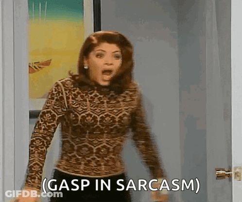 A Woman In A Leopard Print Shirt Is Standing In A Doorway And Says Gasp In Sarcasm GIF