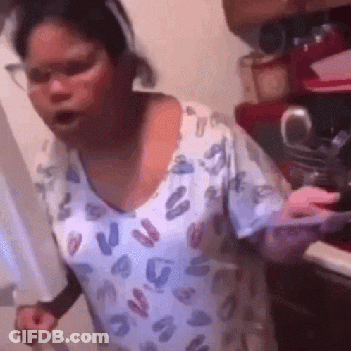 A Woman In A Leopard Print Shirt Is Standing In A Kitchen Holding A Knife . GIF