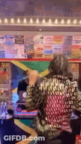 A Woman In A Leopard Print Shirt Is Standing In Front Of A Lottery Machine Holding A Yellow Ribbon . GIF