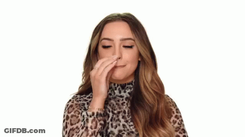 A Woman In A Leopard Print Top Is Making An Ok Sign With Her Hand . GIF